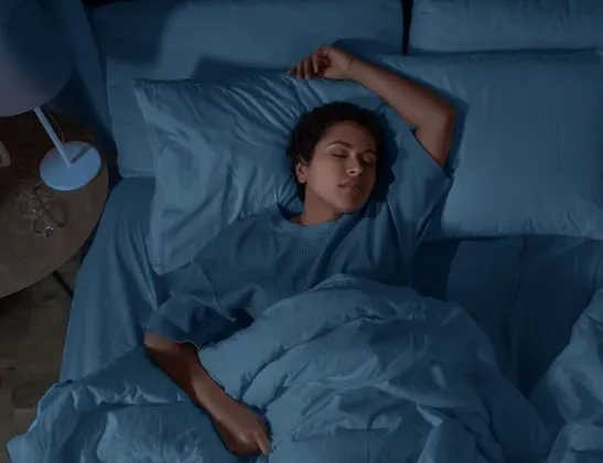 woman sleeping soundly with blue matching sheets